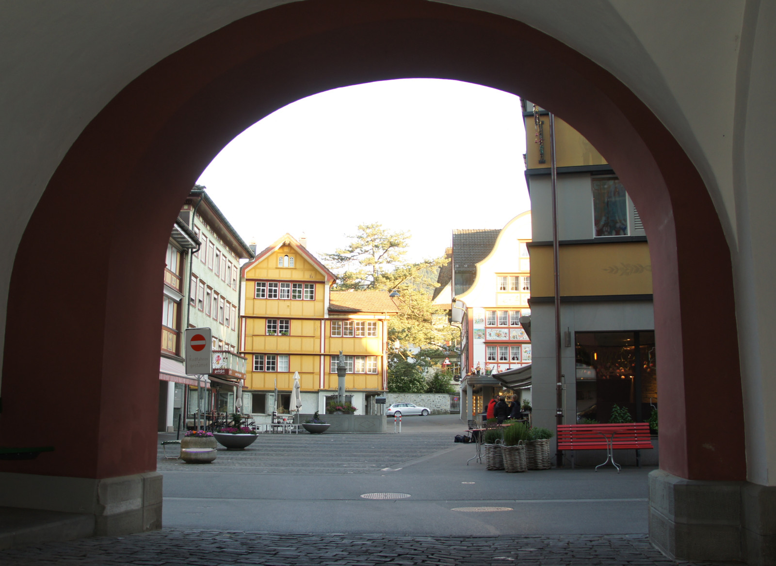Sicht vom Rathausbogen über den Platz und Dorfbrunnen zum gelben Haus Marwies im Hintergrund